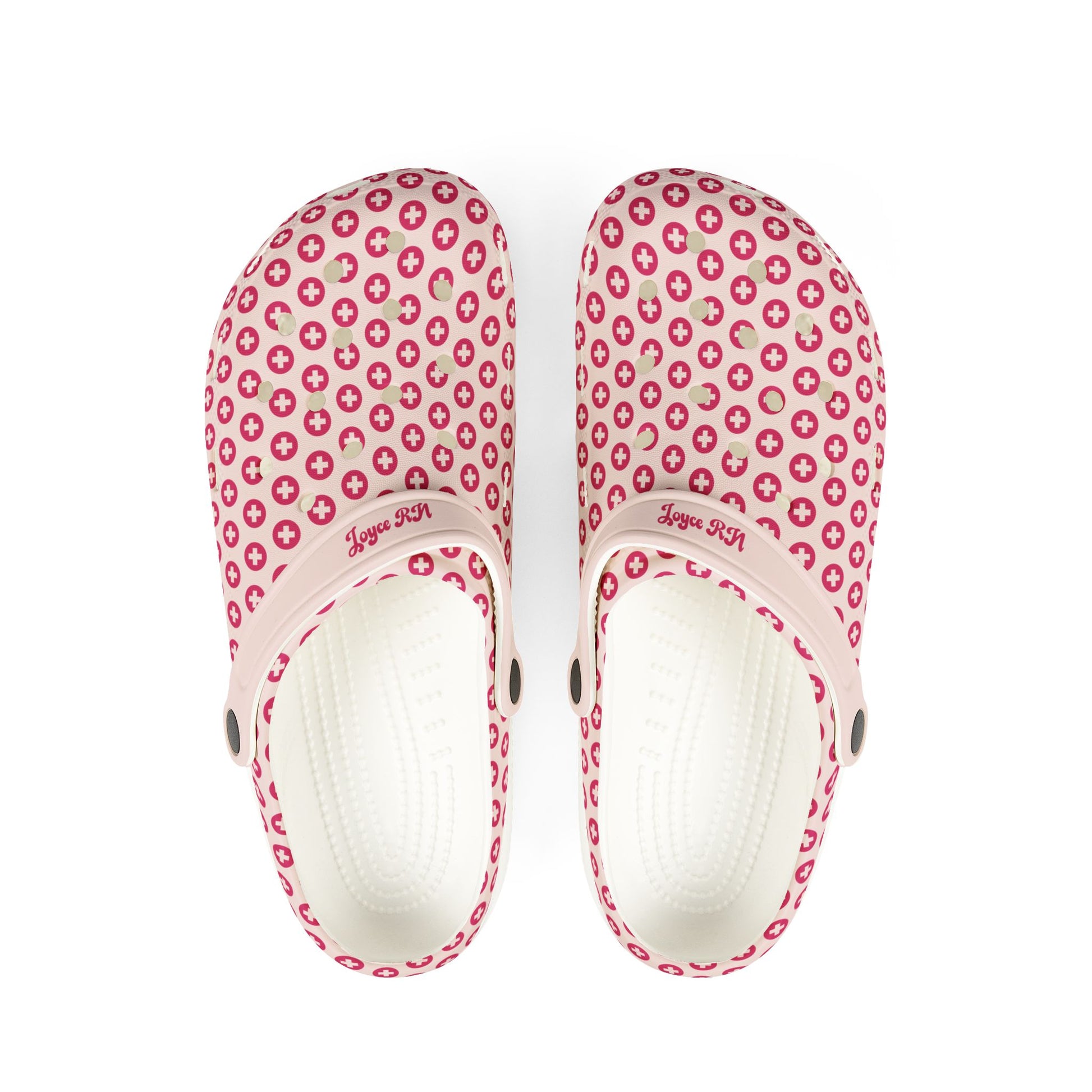 A pair of pink EVA foam rubber clogs with a polka dot design and a personalized strap.